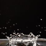 Close-up photo capturing a water droplet splash with ripples against a black background.