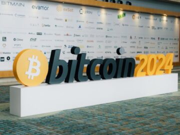 Modern entrance display for Bitcoin 2024 conference with sponsor logos in the background.