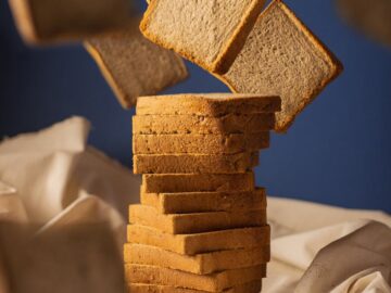Artistic image of bread slices floating against a blue background with a rustic touch.