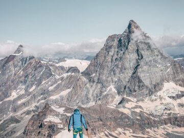 A mountaineer stands facing the iconic Matterhorn in Zermatt, Switzerland for an adventurous climb.
