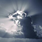 Sunlight breaks through dramatic clouds, creating a stunning sunburst effect.