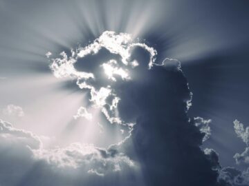 Sunlight breaks through dramatic clouds, creating a stunning sunburst effect.