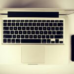 Aerial view of a modern workspace setup featuring a laptop and smartphone on a desk.