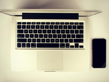 Aerial view of a modern workspace setup featuring a laptop and smartphone on a desk.