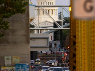 Traffic flows near the iconic Sacramento Capitol Building at sunset.