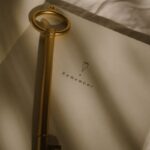 A vintage key placed on an open notebook with 'Remember' text, in soft lighting.