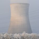 a nuclear power plant surrounded by snow covered trees