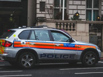 Police vehicle parked on an urban street outside a London building