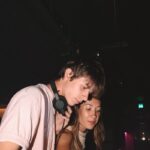 Young DJs perform live set in vibrant nightclub ambiance.
