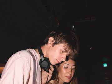 Young DJs perform live set in vibrant nightclub ambiance.