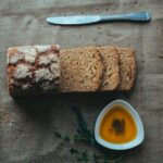 Sliced bread with olive oil on burlap, ideal for culinary themes.