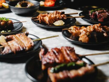 A variety of delicious Japanese yakitori skewers presented on black plates, perfect for food enthusiasts.