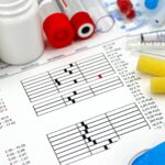 Arrangement of medical equipment, lab tests, and health data on a clinical table.
