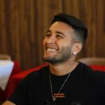 A cheerful man in a cozy restaurant setting, exuding joy and relaxation.