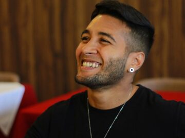 A cheerful man in a cozy restaurant setting, exuding joy and relaxation.