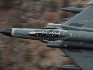 High-speed Turkish military jet flying over rugged terrain, showcasing aviation prowess.