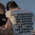 Two individuals showcasing an LGBTQ+ equality message in Istanbul for social change.