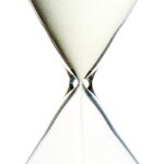 A close-up view of an elegant hourglass with flowing sand, symbolizing the passage of time.