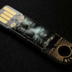 A detailed close-up of a Bitcoin-themed USB device on a black background.