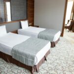 Spacious and luxurious hotel room featuring two comfortable twin beds with stylish design.