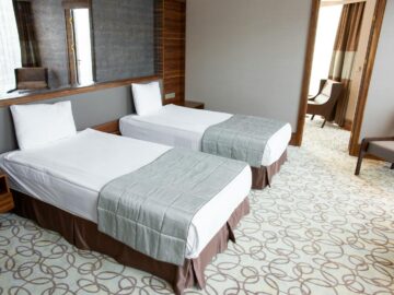 Spacious and luxurious hotel room featuring two comfortable twin beds with stylish design.