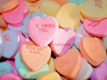 A pile of colorful heart-shaped candies with romantic messages, ideal for Valentine's Day.