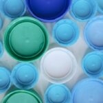 Aerial view of assorted colorful plastic bottle caps highlighting recycling and sustainability.
