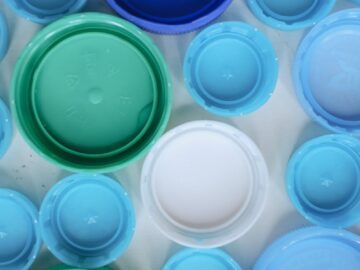 Aerial view of assorted colorful plastic bottle caps highlighting recycling and sustainability.