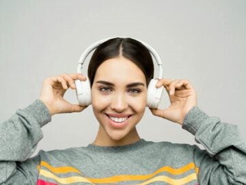Portrait of a woman smiling while enjoying music with wireless headphones.