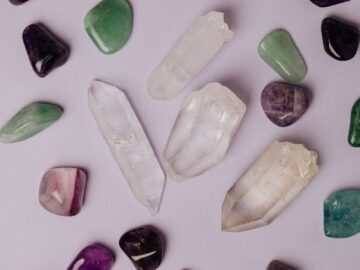 Top view of multicolored polished amethyst jade malachite and colorless rock crystal arranged on gray table in studio