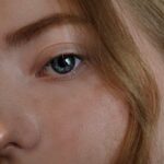 Intimate close-up of a woman's blue eye with blonde hair, capturing natural beauty.