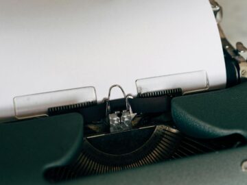 Close-up of a classic vintage typewriter with blank paper ready for typing.
