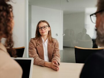 Young woman attending a job interview in a modern office, showcasing confidence and professionalism.