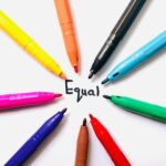 Colorful markers arranged in a circle on white paper around the word 'Equal'.