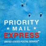 Close-up of a blue USPS mailbox featuring 'Priority Mail Express' text, ideal for postal themes.