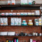 Brick wall shelving in a café with various coffee products and modern decor.