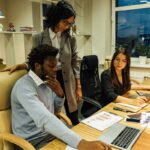 Business team working together at a desk with laptops and documents. Perfect for business collaboration themes.
