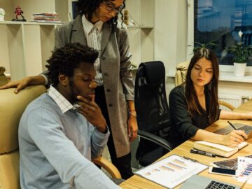 Business team working together at a desk with laptops and documents. Perfect for business collaboration themes.