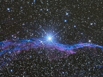 Vibrant image of the Veil Nebula, a supernova remnant in space, with a star-filled background.