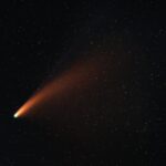 A vibrant comet with a glowing tail traversing the starry night sky, showcasing the wonders of the universe.