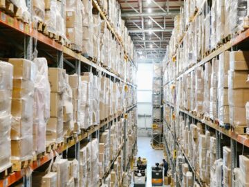 Spacious warehouse aisles lined with shelves stacked with boxes and packaging.