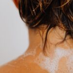Detailed shot of wet hair with soapy water on a back, highlighting cleansing routine.