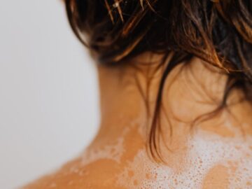 Detailed shot of wet hair with soapy water on a back, highlighting cleansing routine.