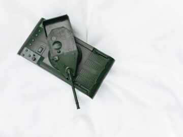 Plastic toy tank with a matte finish on a pristine white backdrop, ideal for military-themed visuals.