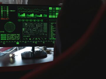 View of a computer monitor displaying green digital security code in an indoor setting.