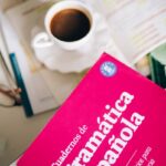 An inviting scene with Spanish grammar notebook and coffee, perfect for study sessions.