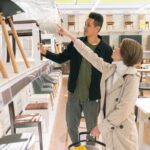 A couple shopping for furniture in a brightly lit store, discussing options.