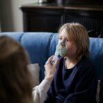 A young boy sits indoors receiving inhalation therapy, highlighting home healthcare.
