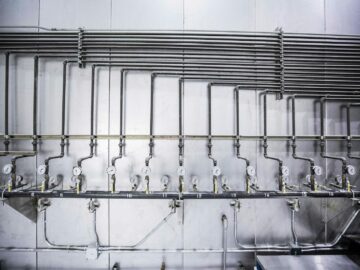 Detailed view of an industrial plumbing system featuring multiple pressure gauges and steel pipes.