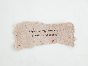 Hand-typed inspirational quote on a textured paper with a minimalist background.